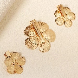 Detailansicht goldener Blumen-Haarspangen mit Metalltextur und Feder-Clip-Mechanismus