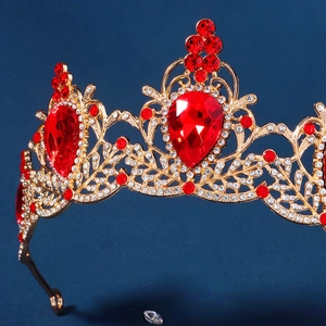 Macro view of Baroque bridal crown with pear-shaped red rhinestones and golden details