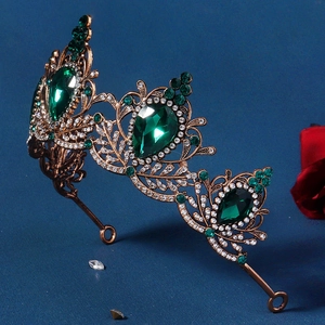 Macro view of vintage baroque tiara with green rhinestones and antique gold alloy texture