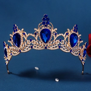Detailed close-up of Baroque gold crown with deep blue crystals and rhinestones