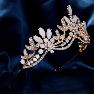 Detailed side view of luxury bridal crown with marquise gems on gold base and blue silk