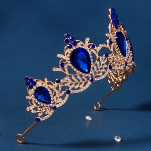 Detailed macro of golden baroque crown with blue teardrop crystals and sparkling rhinestones