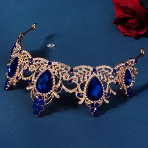 Macro detail of golden baroque crown with blue pear-shaped stones and rhinestones