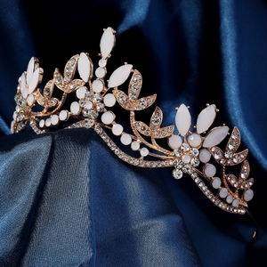 Detail of bridal crown with white rhinestones and gold leaf motifs on blue satin
