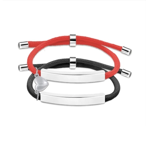Close-up of magnetic heart pendant connecting red and black woven couple bracelets