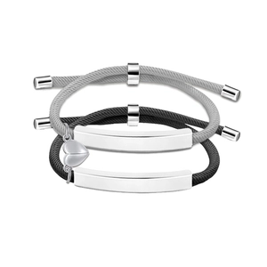 Close-up of magnetic heart pendants and engravable metal plates on braided couple bracelets