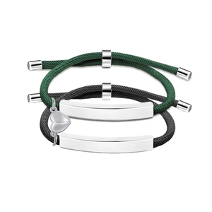 Close-up of woven couple bracelets with magnetic heart charm and metal bar details