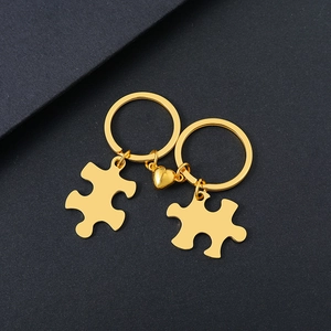 Polished gold stainless steel heart puzzle keychain set for couples on black background