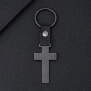 Porte-clés croix noire minimaliste avec lanière en cuir sur un fond gris texturé élégant