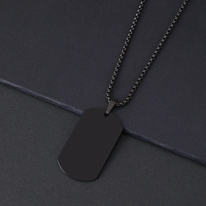 Detailed view of a matte black stainless steel dog tag pendant with a box chain necklace