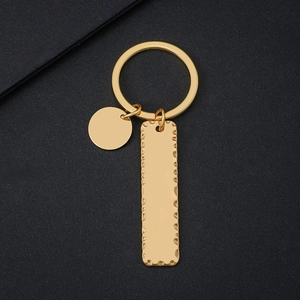 Polished gold metal keychain with hammer-textured rectangular tag and round blank charm