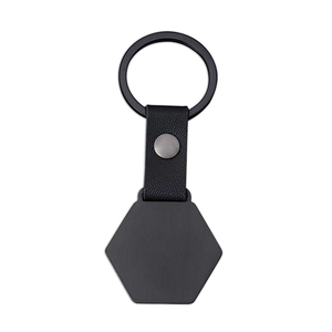 Detail of matte black hexagonal metal keychain with textured litchi grain leather strap