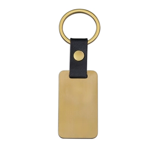 Detail view of rectangular gold metal keychain with black lychee textured leather strap