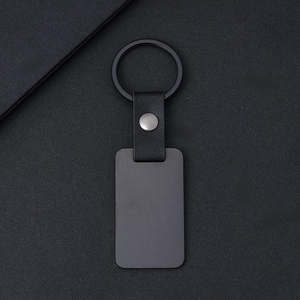 Minimalist black leather keychain with rectangular metal tag and matte brushed finish