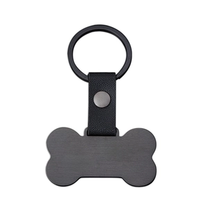 Detalle del llavero en forma de hueso de metal cepillado con correa de cuero negro lichi