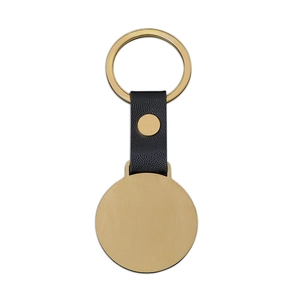 Detail of round gold metal keychain with black lychee grain leather and rivet detail