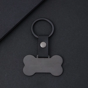Placa para mascota en forma de hueso negro mate con correa de cuero y un llavero metálico