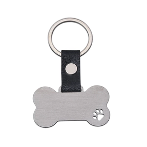 Detail of bone-shaped pet ID tag with black leather strap and laser-cut paw print