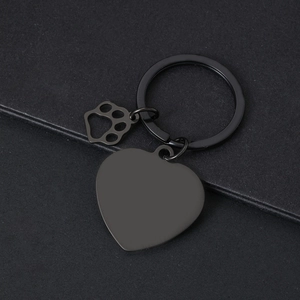 Detail of matte black heart keychain with laser-engraved cat paw pendant and round ring