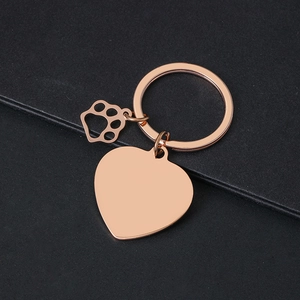 Rose gold heart keychain with hollow paw pendant on a textured dark background