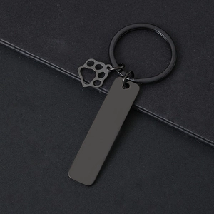 Close-up of black metal keychain featuring a rectangular plate and cat paw charm detail