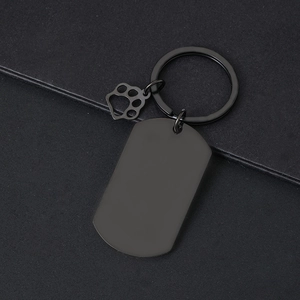 Close-up of black matte stainless steel key ring with hollow paw print charm detail