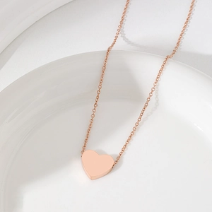 Elegante roségoldene Herzkette auf weißer Keramikschale mit polierter Oberfläche