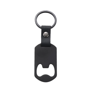 Detail of matte black metal bottle opener keychain with black lychee textured leather strap