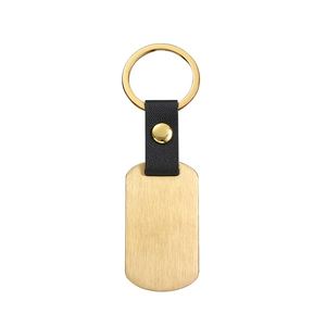 Detail of black lychee grain leather keychain with gold brushed metal tag