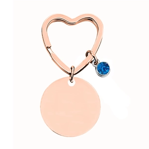 Detailansicht herzförmiger Schlüsselanhänger in Roségold mit blauem Stein und Rundanhänger