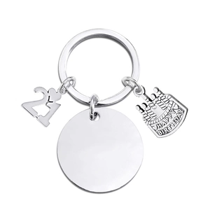 Macro detail of silver birthday keychain with 21, cake charms and blank metal tag