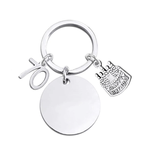 Close-up of silver 70th birthday keychain with engravable round tag and cake charm