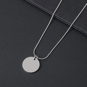 Detailansicht eines minimalistischen runden Anhängers an einer Schlangenkette aus Silber