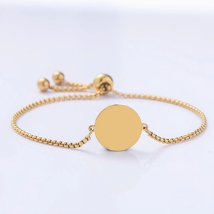 Vista macro del bracciale regolabile in oro con ciondolo rotondo e chiusura a scorrimento