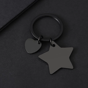 Détail des breloques cœur et étoile en acier inoxydable noir mat sur l'anneau porte-clés