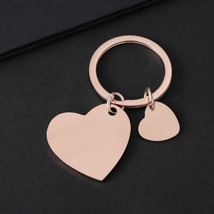Llavero elegante de acero inoxidable oro rosa con colgantes de doble corazón sobre negro