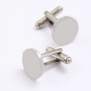 Macro detail of round silver cufflinks showing brushed metal texture and T-bar clasp