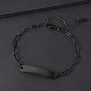 Detail of matte black stainless steel paperclip bracelet with engravable metal plate