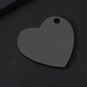 Detail view of heart-shaped black stainless steel tag with laser-cut hole for engraving