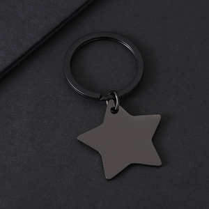 Detailed top view of matte black star-shaped metal keychain on textured black background