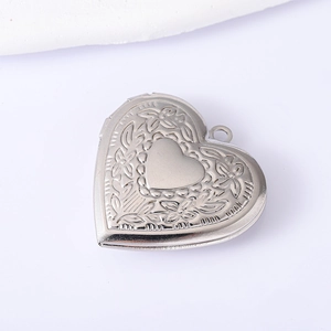 Close-up of engraved floral patterns on silver stainless steel heart locket pendant