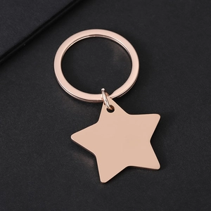 Polished rose gold star-shaped stainless steel keychain on a black textured background