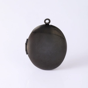 Détail d'un médaillon ovale en acier inoxydable noir brossé avec charnière et boucle