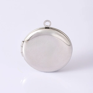 Detailed macro view of a polished stainless steel round photo locket with a side hinge