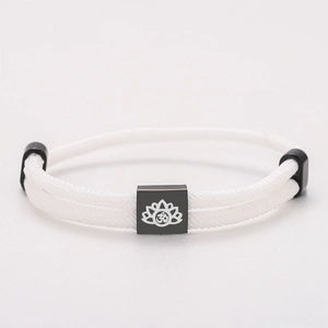Detail view of white braided Milanese rope bracelet with black lotus engraved pendant