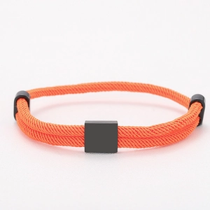 Detailed close-up of orange braided Milanese cord bracelet with black square slider and metal ends