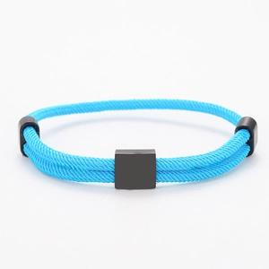 Close-up of bright blue braided cord bracelet with matte black square metal fasteners