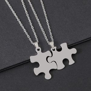 Detail der ineinandergreifenden Puzzle-Anhänger mit silbernen Edelstahl-Gliederketten