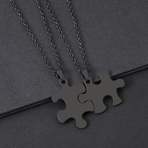 Nahaufnahme der matt schwarzen Edelstahl-Puzzleteil-Halsketten für Paare und Partner
