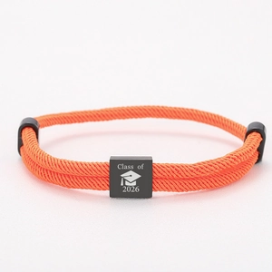Detail eines orangen Abschluss-Armbands mit schwarzem Anhänger der Klasse 2026